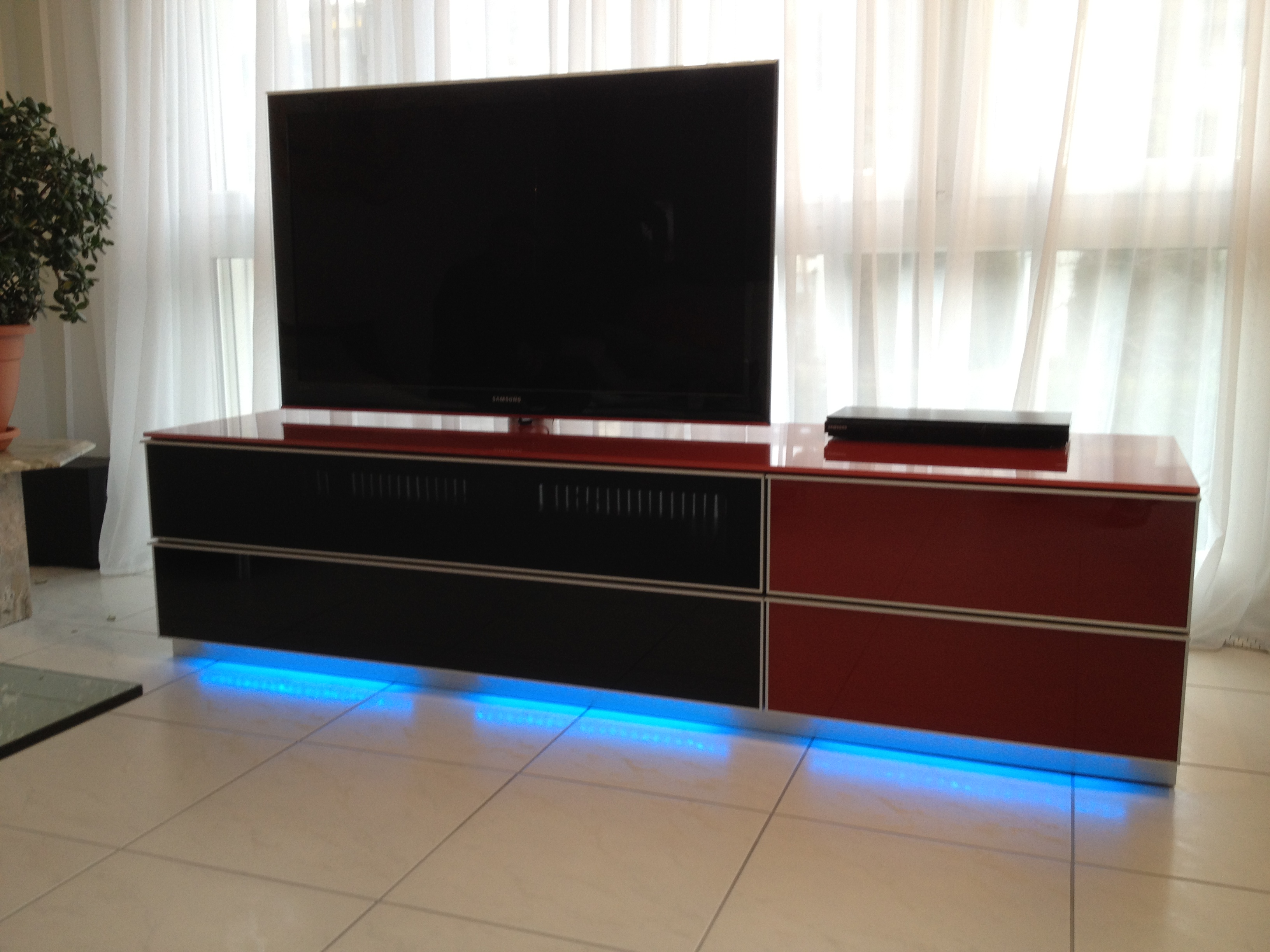 Ausgeschalteter  TV im Wohnzimmer mit blauem Licht am TV-Möbel